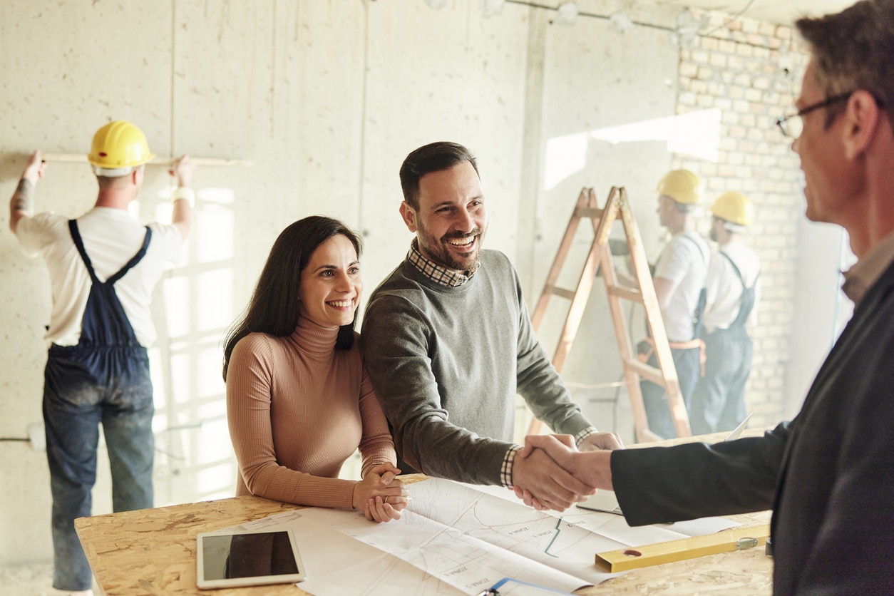 Happy couple came to an agreement with agent at construction site.